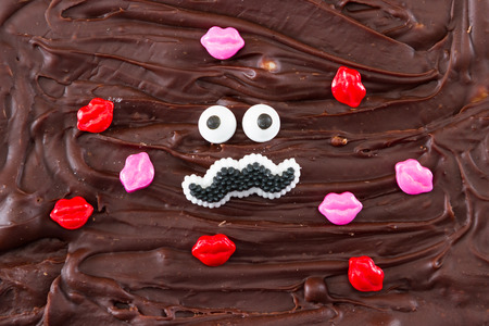 funny face of a male mustache with eyes and lips representing love for fudgeの写真素材