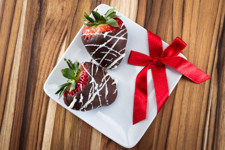 hand dipped strawberries in dark chocolate with a drizzle of white chocolate for a garnishの写真素材
