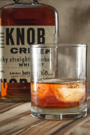 Boulder City Nevada - December 24 : Studio shot of a glass with whiskey and a recognizable label for Knob Creek behind it, December 24 2014 in Boulder City, Nevadaのeditorial素材