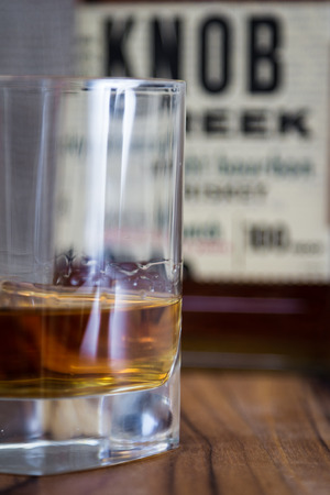 Boulder City Nevada - December 28 : Studio shot of a glass with whiskey and a recognizable label for Knob Creek behind it, December 28 2014 in Boulder City, Nevadaのeditorial素材