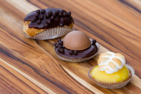 serving of three small desserts on a table, focus on the chocolate panna cotta