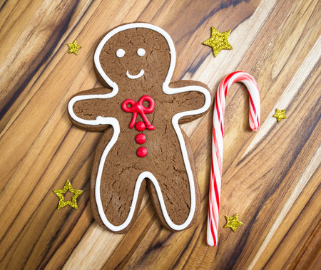 holiday classic, a gingerbread man with a candy cane cookie on a wooden table