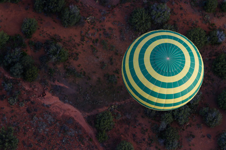view of a hot air balloon soaring above the red rock in Sedona Arizonaの写真素材