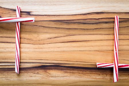 holiday background with stripped peppermint sticks on a wooden backgroundの写真素材