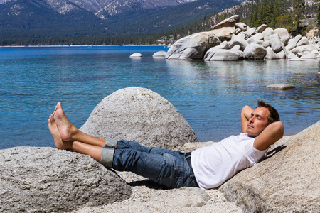 Adult male relaxing in Lake Tahoe enjoying the sunshineの写真素材