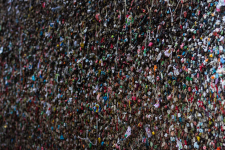 close up of a large wall covered with chewing gum in all colors flavors and smells