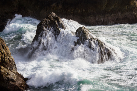 close up of the drama on the California coast with powerful waves splashing on large rocksの写真素材