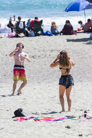 San Luis Obispo, California - young adults having fun and dancing on the beach wearing headphones in a hush concert, May 03 2015 San Luis Obispo, California.のeditorial素材