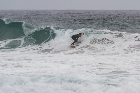 Pfeiffer Beach, California - May 01 : Male surfer in a full suit surfing on the cold waves of the California coast, May 01 2015 Pfeiffer beach, California.のeditorial素材