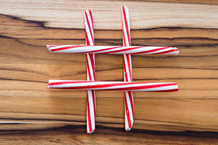 holiday background with stripped peppermint sticks on a wooden backgroundの写真素材
