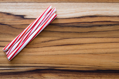 holiday background with stripped peppermint sticks on a wooden background