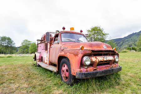 Klamath, California - June 16 : Old ford fire truck rusting away in a meadow, June 16 2015 Klamath, California.のeditorial素材
