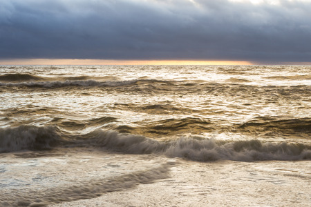 sun setting in the horizon with a dense fog bank typical of the California coast and waves in perpetual motionの写真素材