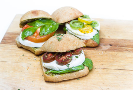 sliders with fresh mozzarella and tomato with fresh basil on a wooden tableの写真素材