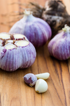 close up of garden fresh raw garlic on a wooden cutting boardの写真素材