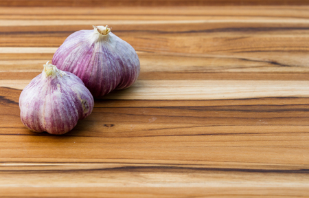 close up of garden fresh raw garlic on a wooden cutting boardの写真素材