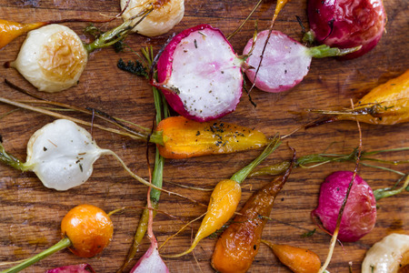fresh baby carrots and radishes roasted and seasoned with oil and spicesの写真素材