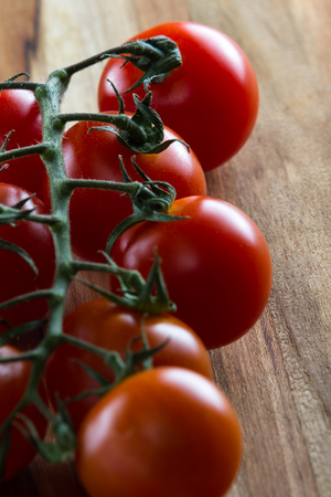 close up of a vine ripen tomato still on the vine with a gorgeous red color and smooth firm textureの写真素材