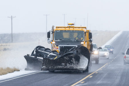 snowy afternoon on a busy highway with traffic and low visibility for a winter caution concept