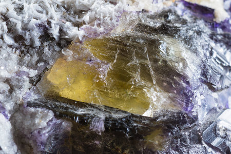 close up of a beutiful piece of crystal with dark purples and yellow with clear sections