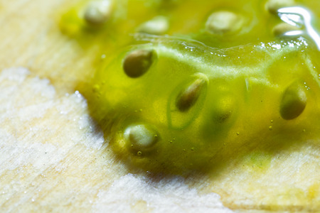 close up of seeds from a very juicy greenish heirloom tomato on a kitchen tableの写真素材