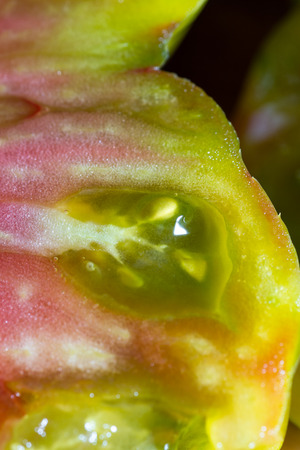 beautiful flavorful tomato cut in half  with a colorful pattern and slimy textureの写真素材