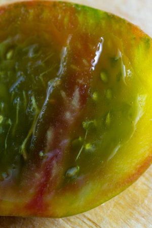 beautiful flavorful tomato cut in half  with a colorful pattern and slimy textureの写真素材