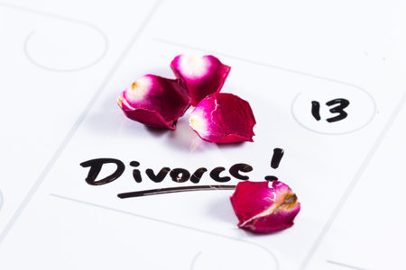 the word divorce hand written on a dry erase calendar with a dead rose next to it