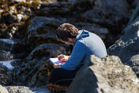San Luis Obispo, California - Young man writing while getting inspired by the ocean, May 03 2015 San Luis Obispo, California.のeditorial素材