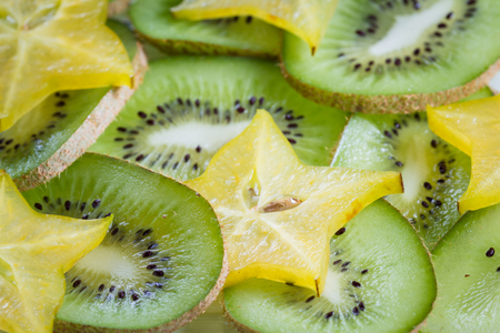 fresh sliced tropical fruit on a plate including kiwi and fresh carambolaの写真素材