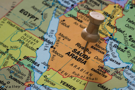 close up of the words Saudi Arabia on a world map marked with a push pin