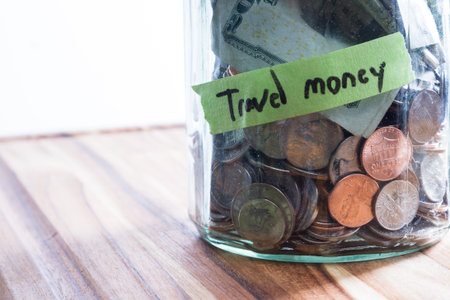 close up of a jar with money and a label using green tape and a black marker