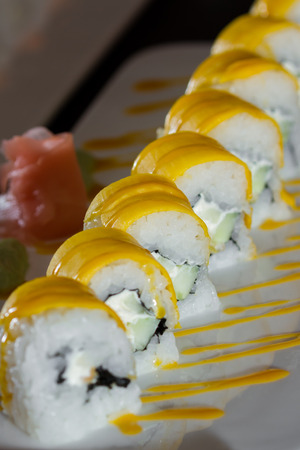 beautifully presented and freshly prepared sweet mango sushi roll served on a white plateの写真素材