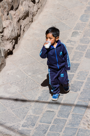 Pisac, Peru - May 15: Young boy walking dressed up in full Adidas clothing in the Sacred Valley Market. May 15 2016, Pisac Peru.のeditorial素材