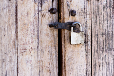 close up of an old wooden door with a newer lockの写真素材