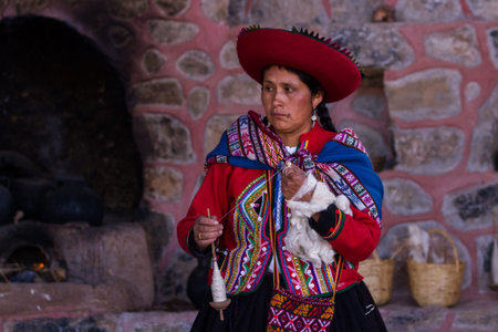 Chinchero Peru -May 18 : Native Cusquena woman dressed in traditional colorful clothing explaining how to spin wool . May 18 2016, Chinchero Peru.のeditorial素材