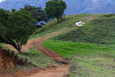 dirt road over a small mountain with mud and holes from weather and vehicles in a rural area of Costa Ricaの写真素材