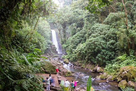 Alajuela, Costa Rica - May 02: families and friends enjoying the view of a beautiful waterfall in the rainforest. May 02 2016 Alajuela, Costa Rica.のeditorial素材