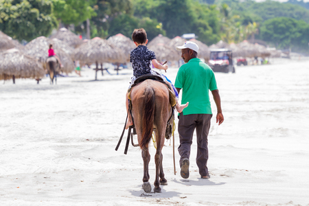 Santa Clara, Panama- June 12: young boy on a horse riding along the beach in Panama. June 12 2016, Santa Clara, Panama.のeditorial素材