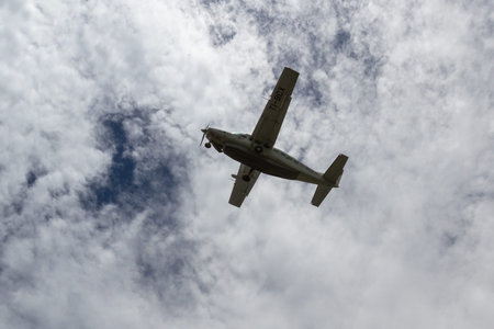 Tambor, Costa Rica - June 22: Local plane in mid air with cloudy skies in the background. June 22...