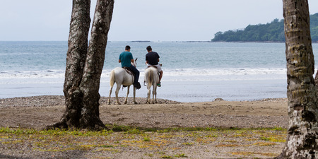 Tambor, Costa Rica - June 21: Friends enjoying a horseback ride on the beach. June 21 2016, Tambor, Costa Rica.のeditorial素材