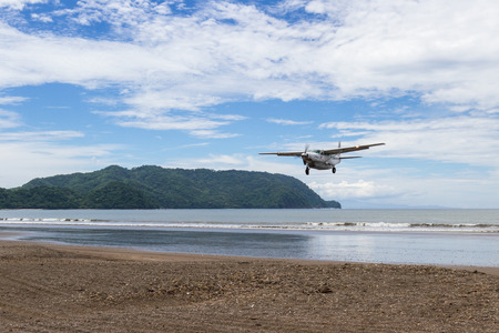 Tambor, Costa Rica - June 22: Sanasa a local airline approaching the runway with a beach scene in the background. June 22 2016, Tambor, Costa Rica.のeditorial素材