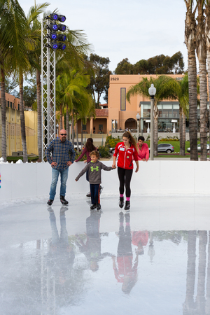 San Diego, California - November 26: Teenage girl teaching children how to ice skate in southern California. November 26 2016, San Diego, California.のeditorial素材