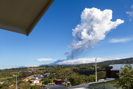 Heredia, Costa Rica - April 14: Plum of steam and ash from volcanic activity towering above the Poas Volcano and surrounding neighborhoods. April 14 2017, Heredia, Costa Rica.のeditorial素材