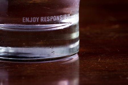 concept for drinking responsibly with the words enjoy responsibly edged on a glass with an alcoholic...