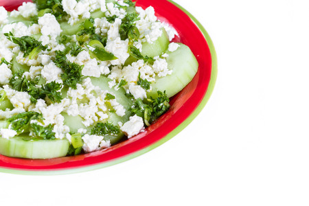 close up of a cucumber and feta cheese salad topped with green onion and parsley dressed with olive oil and lemon juiceの写真素材