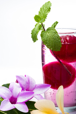 refreshing sparkling cocktail with frozen red juice garnished with beautiful wildflowers isolated on a white backgroundの写真素材