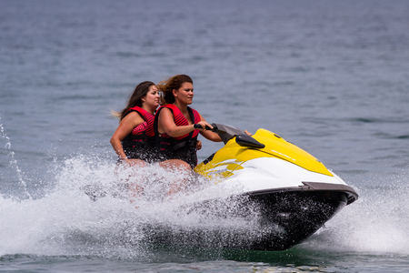 Guanacaste, Costa Rica- July 25: female firiends riding a wave runner in Nacascolo Beach. July 25 2017, Guanacaste, Costa Rica.のeditorial素材