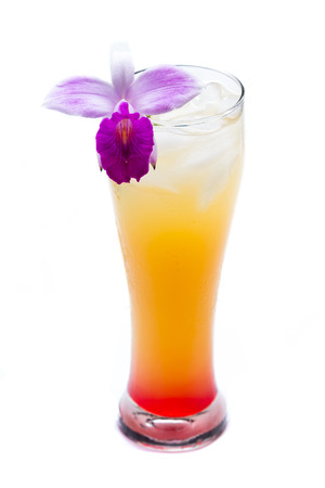 close up of a cocktail layer with red on the bottom and orange on top isolated on a white background and garnished with a carambola slice and a bamboo orchidの写真素材