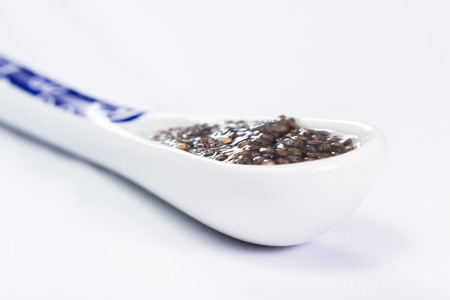 white ceramic spoon with wet chia seeds with a gummy sticky textureの写真素材